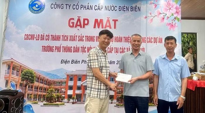Lãnh đạo Công ty Minh Quý Điện Biên trao quà tri ân tập thể công nhân Công ty Cổ phần Cấp nước Điện Biên đã hỗ trợ hoàn thành hạng mục nước, điện tại Trường phổ thông nội trú liên cấp Núa Ngam. (Ảnh: LÊ LAN)