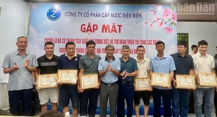Đồng chí Nguyễn Lệ Quế (người thứ 5 từ trái sang), Chủ tịch Hội đồng Quản trị Công ty Cổ phần Cấp nước Điện Biên cùng lãnh đạo Công ty trao Giấy khen tặng các công nhân đã tích cực góp sức hoàn thành thi công 7 trường phổ thông nội trú liên cấp. (Ảnh: LÊ LAN)