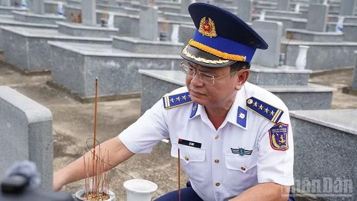 Đại tá Lê Huy, Chính ủy Vùng Cảnh sát biển 2 thắp hương tưởng niệm các liệt sĩ tại Nghĩa trang liệt sĩ Đức Lân. (Ảnh: Cảnh sát biển)