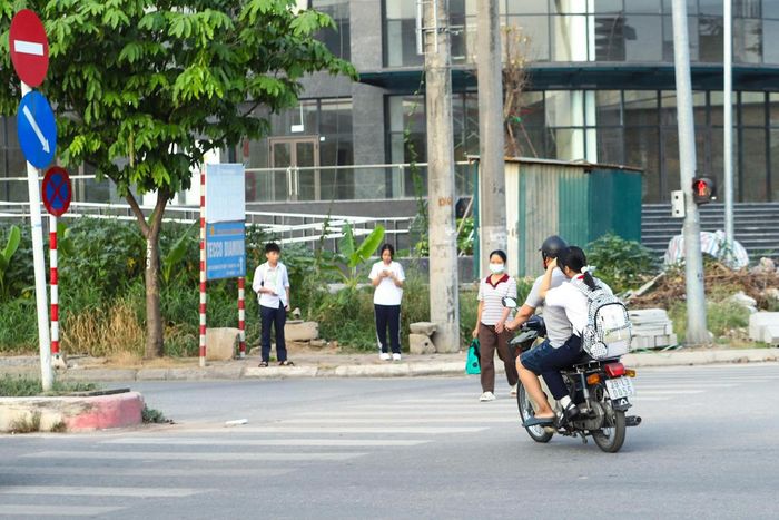 Trường hợp phụ huynh chở học sinh ngồi trên xe máy không đội mũ bảo hiểm đi học. 