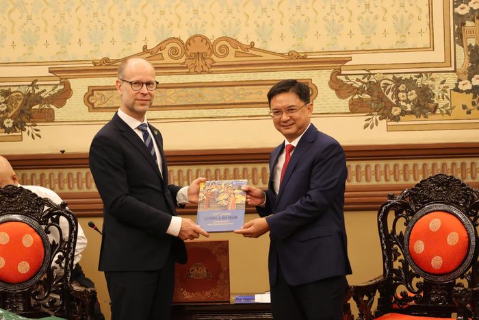 Phó Thị trưởng thành phố Leipzig Clemens Schülke trao quà lưu niệm tặng Phó Chủ tịch UBND TPHCM Nguyễn Mạnh Cường. Ảnh: THỤY VŨ