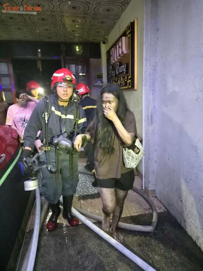 Sau khi được đưa ra ngoài, một số nạn nhân trong tình trạng người phủ đầy khói đen, được cảnh sát hỗ trợ sơ cứu.