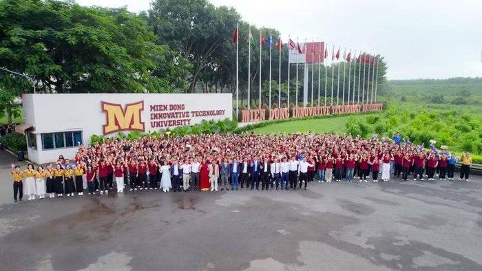 Lãnh đạo nhà trường, đối tác chụp hình lưu niệm tại cổng chính trường. Ảnh: NTCC.