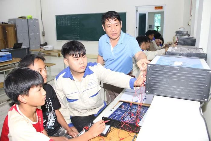 Ông Vũ Khắc Khôi, Trưởng Khoa điện công nghiệp chỉ dẫn sinh viên thực hành trên mô hình.