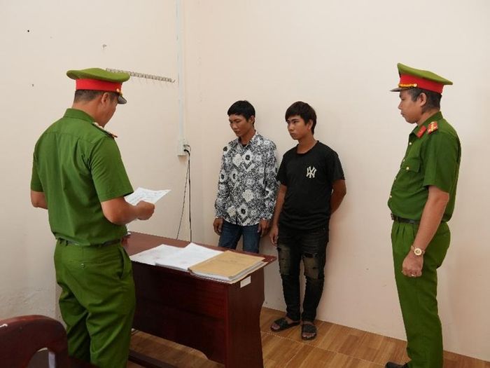 Cơ quan điều tra tống đạt các Quyết định khởi tố Lê Văn Khanh và Lê Văn Nhàn (áo đen). (Ảnh:CACT)