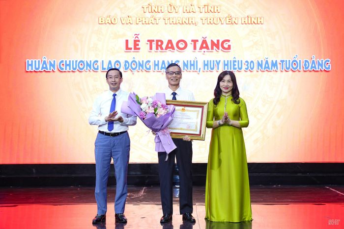 Các đồng chí: Nguyễn Thị Mai Thủy - Phó Bí thư chuyên trách Đảng ủy các cơ quan Đảng tỉnh, Nghiêm Sỹ Đống - Giám đốc Báo và phát thanh, truyền hình Hà Tĩnh trao Huân chương Lao động hạng Nhì cho đồng chí Đinh Văn Thiềm - nguyên Giám đốc Đài PT-TH Hà Tĩnh.