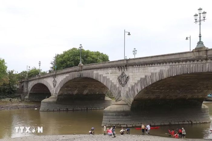 Mực nước sông Thames của Anh hiện ở mức rất thấp trong nhiều năm. Nước sông xuống thấp làm trơ các trụ của cây cầu Kew bắc qua sông Thames đoạn ở London. (Ảnh: Hữu Tiến/TTXVN)
