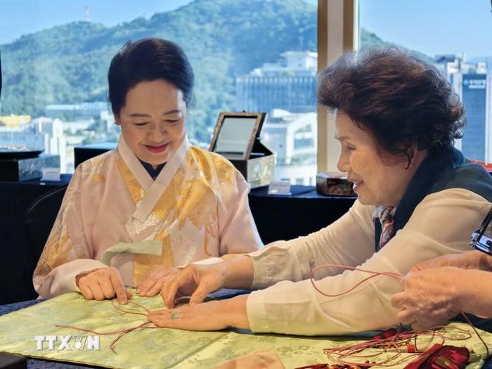 Phu nhân Nguyễn Thị Thanh Nga trải nghiệm nghệ thuật thắt nút chỉ Hàn Quốc. (Ảnh: Đào Lâm/TTXVN)