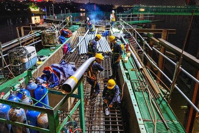 Công trường cầu Trần Hưng Đạo duy trì 28 mũi thi công ngày đêm với 700 người và hơn 120 máy móc, thiết bị.