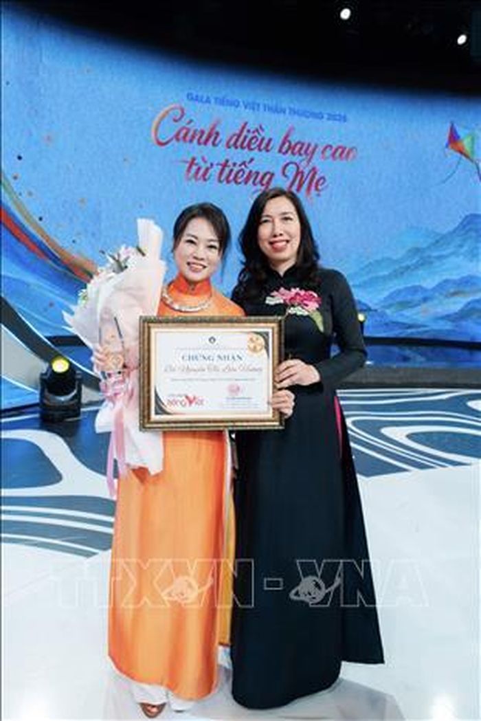 Cô Nguyễn Thị Liên Hương (trái) cùng Thứ trưởng Bộ Ngoại giao Lê Thị Thu Hằng tại Lễ trao danh hiệu Sứ giả tiếng Việt ở nước ngoài năm 2026. Ảnh: TTXVN phát