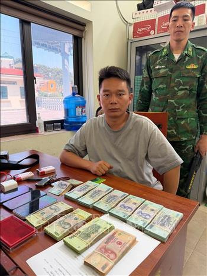 Đối tượng Triệu Phó Nghị cùng tang vật là 355 triệu đồng. Ảnh: TTXVN phát