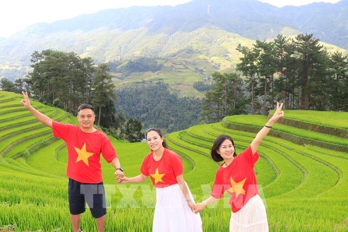 Gia đình anh Lê Nguyên Việt ở Hải Phòng tranh thủ chụp ảnh lưu lại kỷ niệm khi đến võng lúa Mù Cang Chải. Ảnh: Tuấn Anh - TTXVN