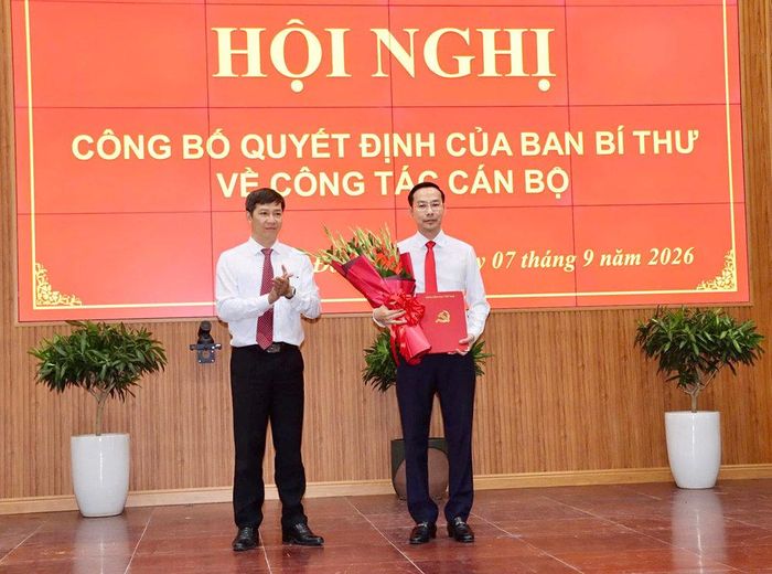 Ông Nguyễn Thành Tâm trao quyết định và hoa chúc mừng ông Nguyễn Thanh Nhàn.