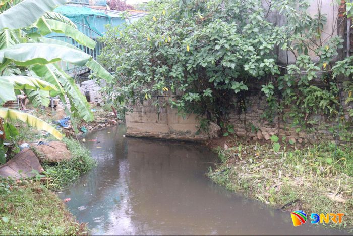 Một công trình phụ được xây dựng choán một nửa bề rộng lòng mương, làm co hẹp dòng chảy và ảnh hưởng thoát nước xuống hạ lưu. Ảnh: HOÀNG HIỆP