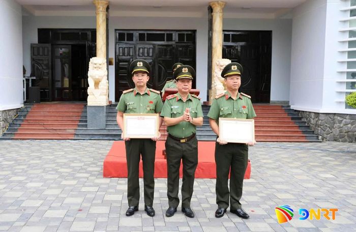 Thiếu tướng Nguyễn Hữu Hợp (đứng giữa) trao bằng khen cho Đại tá Nguyễn Đại Đồng và Thượng tá Nguyễn Kim Trung, Phó Giám đốc Công an thành phố. Ảnh: A.KHÔI