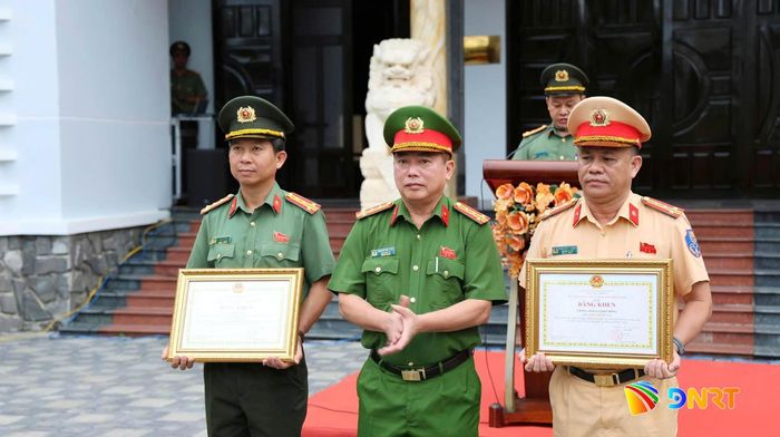Lãnh đạo Công an thành phố trao bằng khen của Chủ tịch UBND thành phố cho Phòng Cảnh sát giao thông và Đại tá Lê Cao Tâm, Trưởng phòng An ninh mạng và phòng, chống tội phạm sử dụng công nghệ cao. Ảnh: A.KHÔI