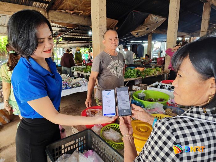 Thanh niên hướng dẫn người dân cài đặt và sử dụng các ứng dụng thanh toán không dùng tiền mặt. Ảnh: TRUNG THỰC