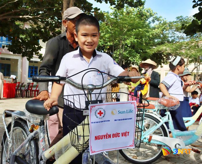 Em Nguyễn Đức Việt, học sinh Trường Tiểu học Junko phân hiệu 2 vui mừng bên chiếc xe đạp mới. Ảnh: XUÂN SƠN
