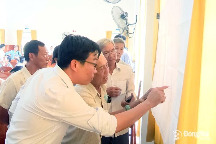 Người dân xã An Phước xem thông tin về dự án. Ảnh: Lê An