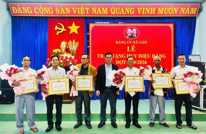 Bí thư Đảng ủy xã Gào Nguyễn Hữu Sung trao huy hiệu Đảng cho các đảng viên. Ảnh: Bá Bính