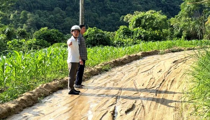Nước mưa cuốn đất, cát tràn xuống mặt đường vào thôn Nậm Đét, gây khó khăn cho việc đi lại.