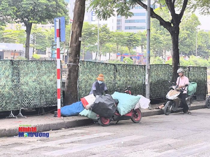 Một đoạn vỉa hè lối bờ sông Tô Lịch được trưng dụng làm nơi để thùng rác