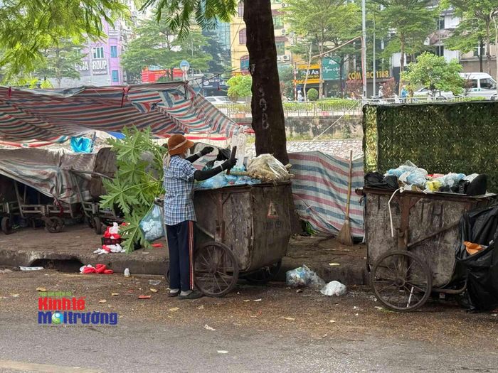 Xe rác được tập kết dưới vỉa hè trong khi chờ xe rác đến thu gom, vận chuyển đi nơi khác (Ảnh: Người dân cung cấp).