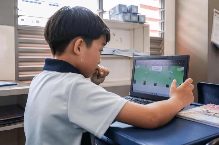 Em Leong Jun Han, 9 tuổi, học sinh trường tiểu học Dazhong, đang chơi một phiên bản Flappy Bird do thầy Kenny Ng, giáo viên tiếng Trung, thiết kế. Ảnh: Brian Teo/The Straits Times
