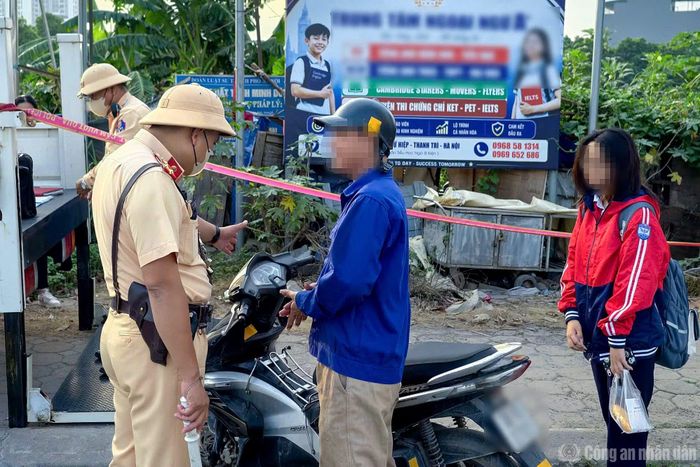 Một trường hợp phụ huynh chở học sinh ngồi trên xe máy không đội mũ bảo hiểm đi học.