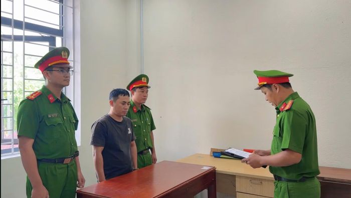Điều tra viên tống đạt quyết định khởi tố bị can và công bố lệnh bắt tạm giam Nguyễn Ngọc Trung.