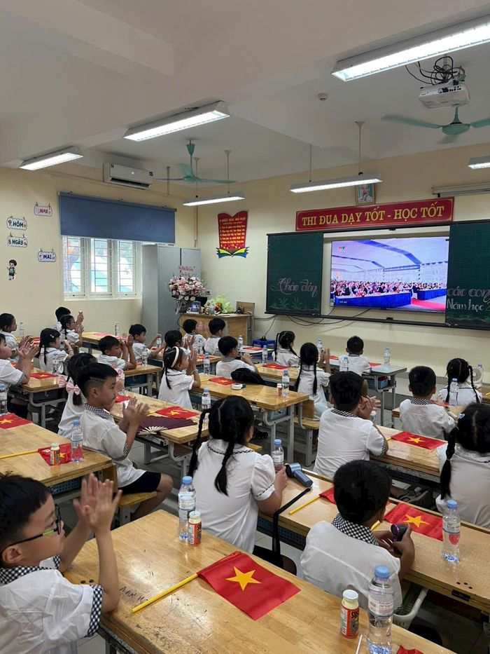 Cô và trò lớp 2A6 theo dõi cầu truyền hình khai giảng năm học mới 2026 - 2027 tại lớp học. Ảnh: NVCC