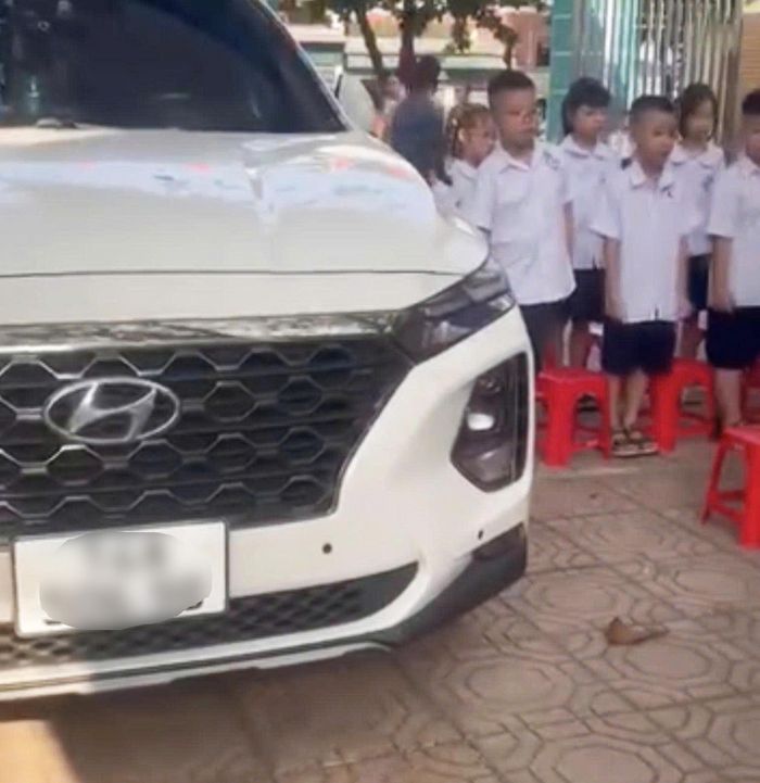 Hình ảnh chiếc ô tô đỗ chình ình ngay trong khu vực học sinh tập trung chào cờ đầu tuần gây xôn xao dư luận. (Ảnh cắt từ video)