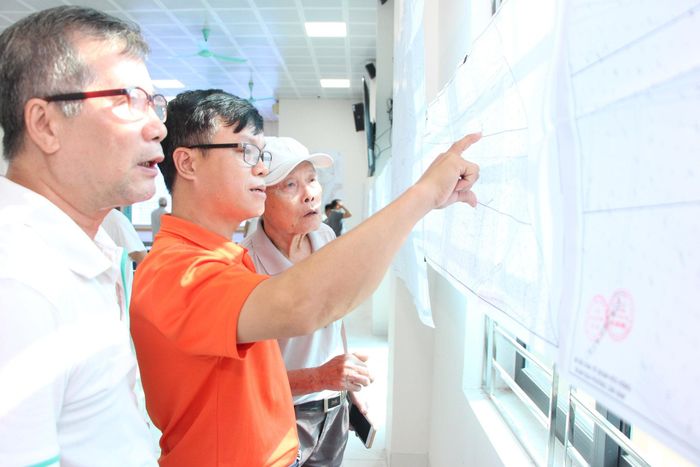 Ông Nguyễn Hữu Tính (áo cam) theo dõi quy hoạch khu dân cư truyền thống Thúy Lĩnh. Ảnh: MH
