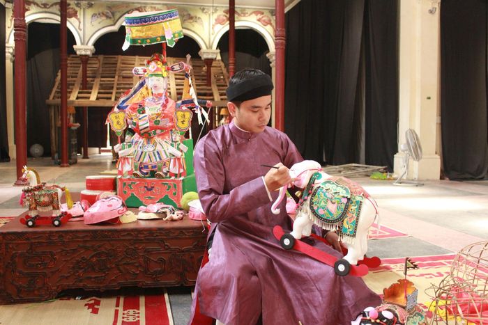 Họa sĩ trẻ Nguyễn Văn Bắc, đại diện thương hiệu Thong Dong trình diễn quá trình chế tác linh vật đồ chơi lấy cảm hứng từ mỹ thuật cổ Việt Nam. Ảnh: Vi Giáng