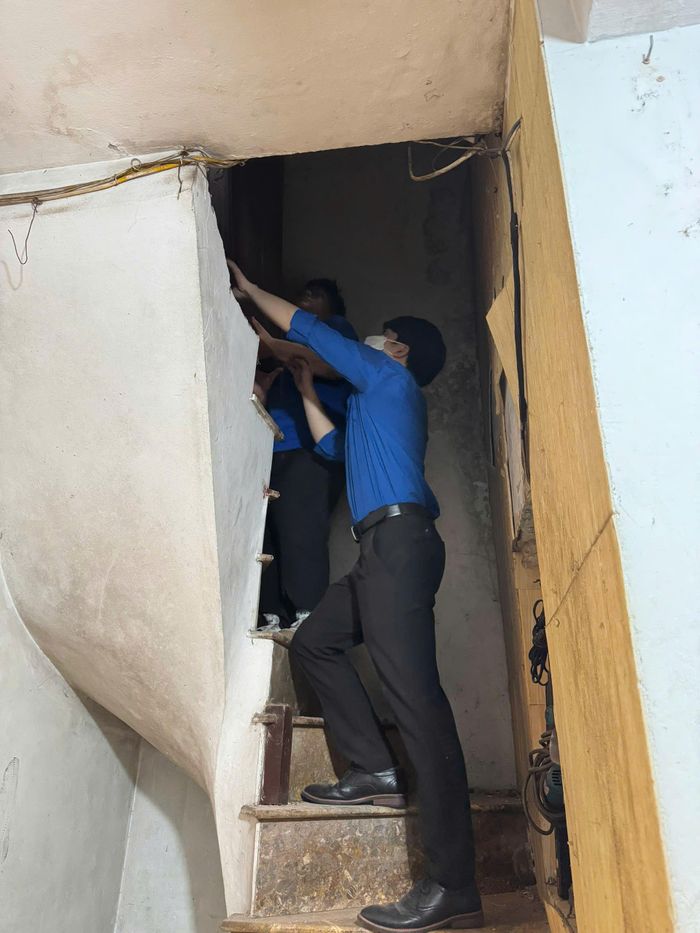 Tại những căn nhà có cầu thang và lối đi hẹp, việc thu dọn, vận chuyển đòi hỏi sự cẩn thận và phối hợp của nhiều người. Ảnh: H.Duy