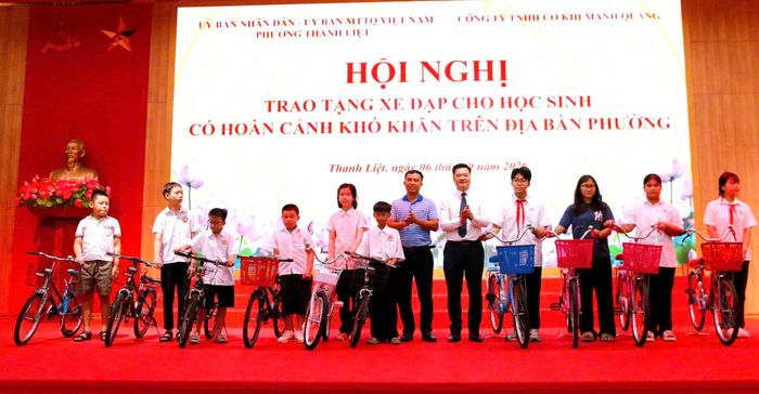 Phó Chủ tịch UBND phường Thanh Liệt Nguyễn Anh Tuấn và đại diện Công ty TNHH Cơ khí Mạnh Quang trao tặng 100 xe đạp cho học sinh có hoàn cảnh khó khăn trên địa bàn. Ảnh: PV