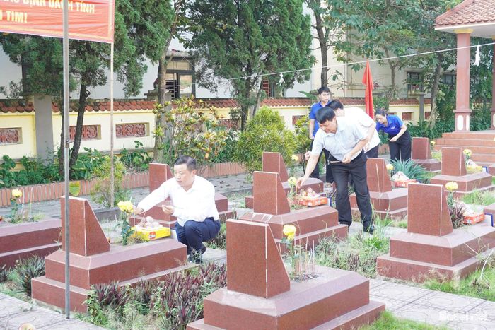 Lãnh đạo xã Dân Hòa dâng hương các Anh hùng liệt sĩ trước khi thực hiện lấy mẫu hài cốt, xác định danh tính liệt sĩ. Ảnh: Lê Dung.