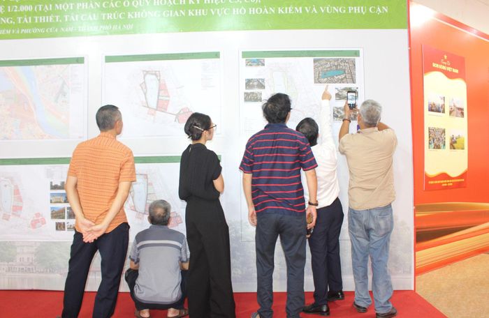 Nhiều người dân không chỉ góp ý kiến mà còn chụp từng hình ảnh, phương án để nghiên cứu. Ảnh: Đình Hiệp