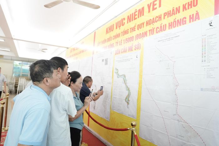 Nhiều người dân không chỉ góp ý kiến mà còn chụp từng hình ảnh, phương án để nghiên cứu. Ảnh: Hồng Thái