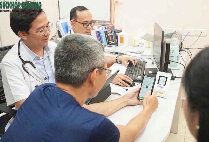Bác sĩ hướng dẫn bệnh nhân kiểm tra kết quả qua app và thanh toán qua quét mã QR. Ảnh: Bệnh viện Bạch Mai