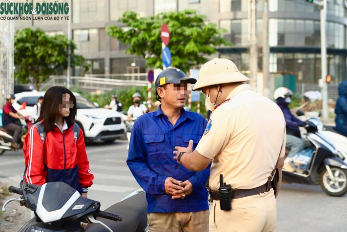 Sáng 7/9, tại nút giao Nguyễn Bặc - Nguyễn Bồ, nhiều trường hợp phụ huynh chở con đến trường nhưng chưa bảo đảm quy định về đội mũ bảo hiểm, nhiều người đội mũ cho mình nhưng để con 'đầu trần'. (Ảnh Thành Long)