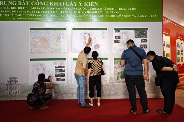 Các hộ dân sinh sống lâu năm tại khu vực lân cận hồ Gươm theo dõi sơ đồ quy hoạch, đối chiếu các phân khu quảng trường mới với vị trí sinh sống hiện tại.
