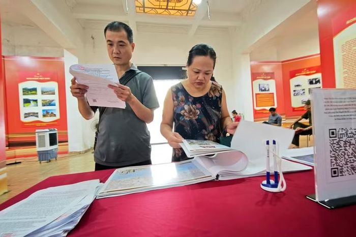 Người dân đọc tờ phiếu khảo sát do ủy ban nhân dân phường phát hành, đọc kỹ từng tiêu chí trước khi ghi lại những kiến nghị về chính sách an cư.