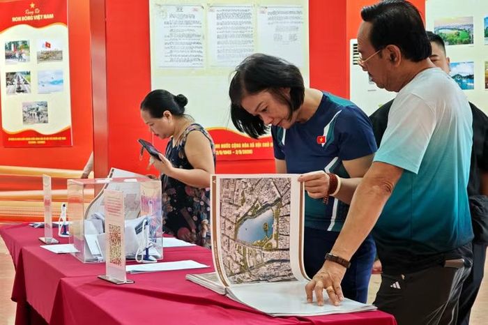 Tập thuyết minh quy hoạch chi tiết đóng quyển khổ lớn trên bàn được lật mở liên tục để người dân tìm hiểu phương án kiến trúc cụ thể.