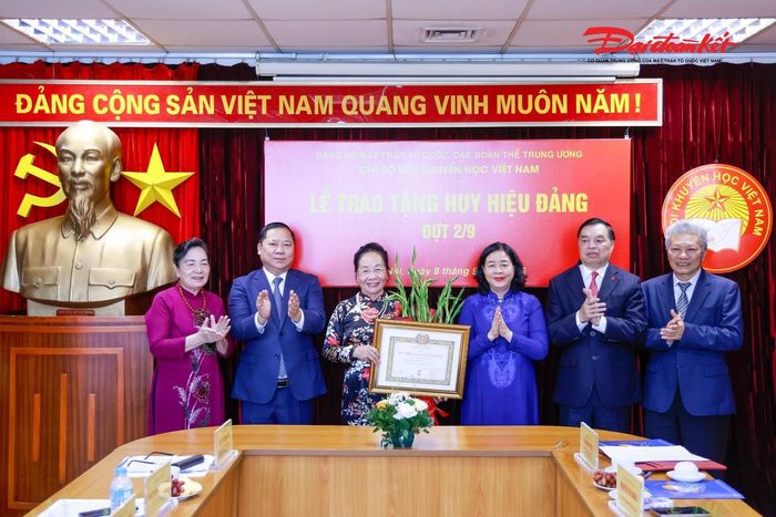 Chủ tịch Bùi Thị Minh Hoài trao tặng Huy hiệu 45 năm tuổi Đảng và tặng hoa chúc mừng GS.TS Nguyễn Thị Doan. Ảnh: Quang Vinh.