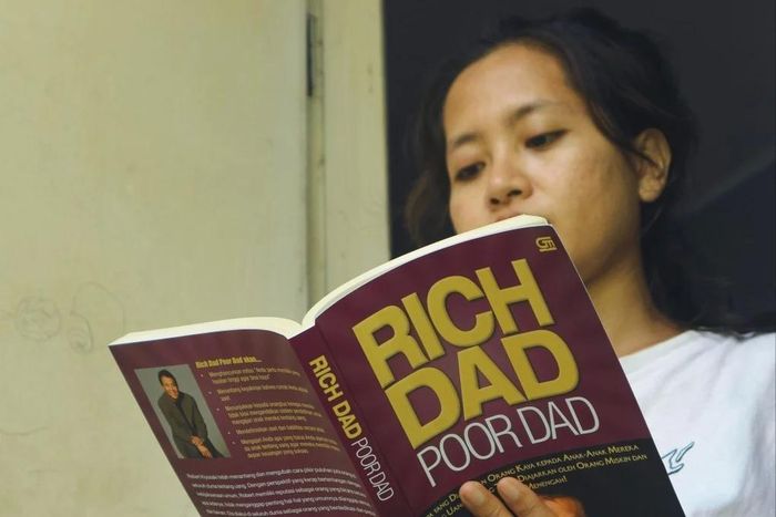 Một phụ nữ trẻ tại Indonesia đọc cuốn Cha giàu, cha nghèo của Robert Kiyosaki. Ảnh: Shutterstock.