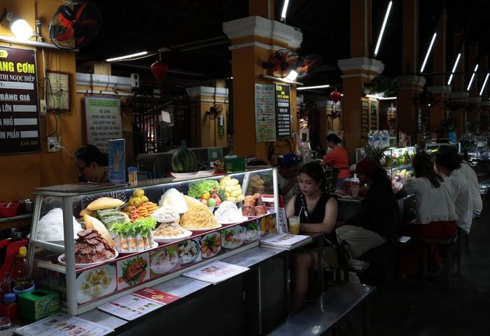Du khách thưởng thức ẩm thực tại chợ Hội An. Ảnh: Đỗ Trưởng - TTXVN
