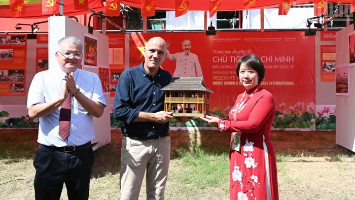 Phó Giám đốc Khu Di tích Chủ tịch Hồ Chí Minh tại Phủ Chủ tịch Cù Thị Minh trao quà lưu niệm "Mô hình Nhà sàn Bác Hồ" - một biểu tượng của dân tộc Việt Nam tặng Tổng Bí thư Đảng Cộng sản Bồ Đào Nha Paulo Raimundo.
