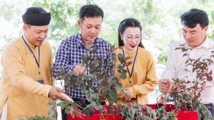 Nghệ nhân Đào Đức Hiếu cùng thủ nhang Đền Thần Nông Nguyễn Hoàng Diệu Ngân (áo dài vàng) giới thiệu với khách tham quan về một số loại thảo dược. (Ảnh: BTC)
