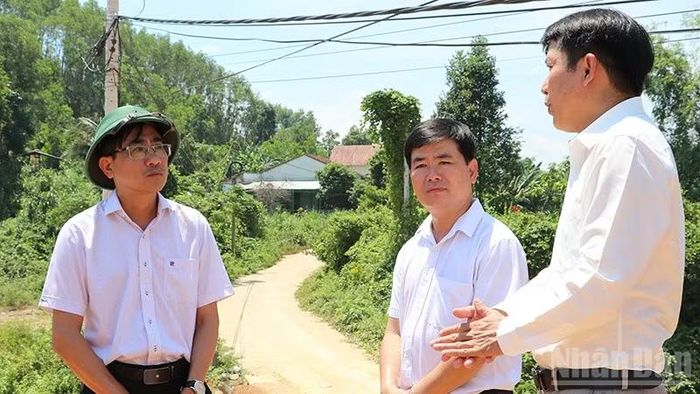 Lãnh đạo xã Hiệp Đức báo cáo tình hình dự án cầu Tân Bình và đường tránh quốc lộ 14E qua nội thị Tân Bình với Chủ nhiệm Ủy ban Kiểm tra Thành ủy Đà Nẵng Trần Thắng Lợi (bên trái). (Ảnh: ANH QUÂN)